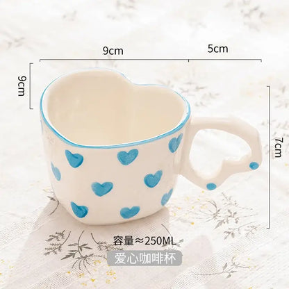 White ceramic love mug with hand painted heart handle and blue heart details in kitchen saucer set