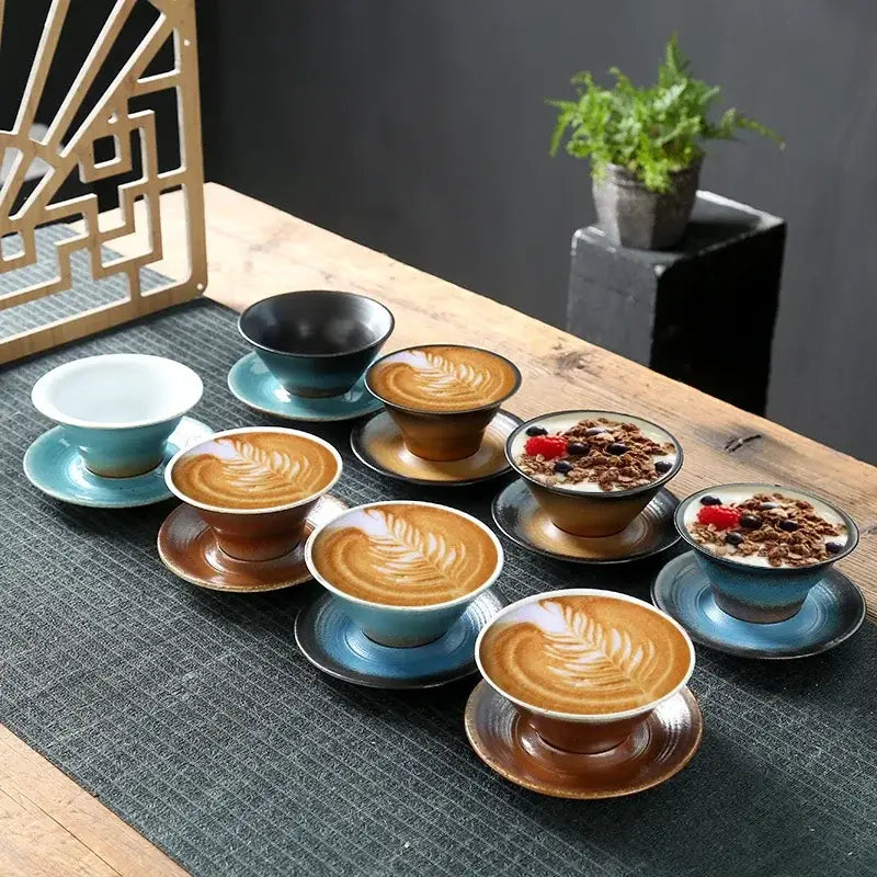 Set of handcrafted brown and amber ceramic latte coffee cups and saucers with glossy glaze and leaf-patterned latte coffee art