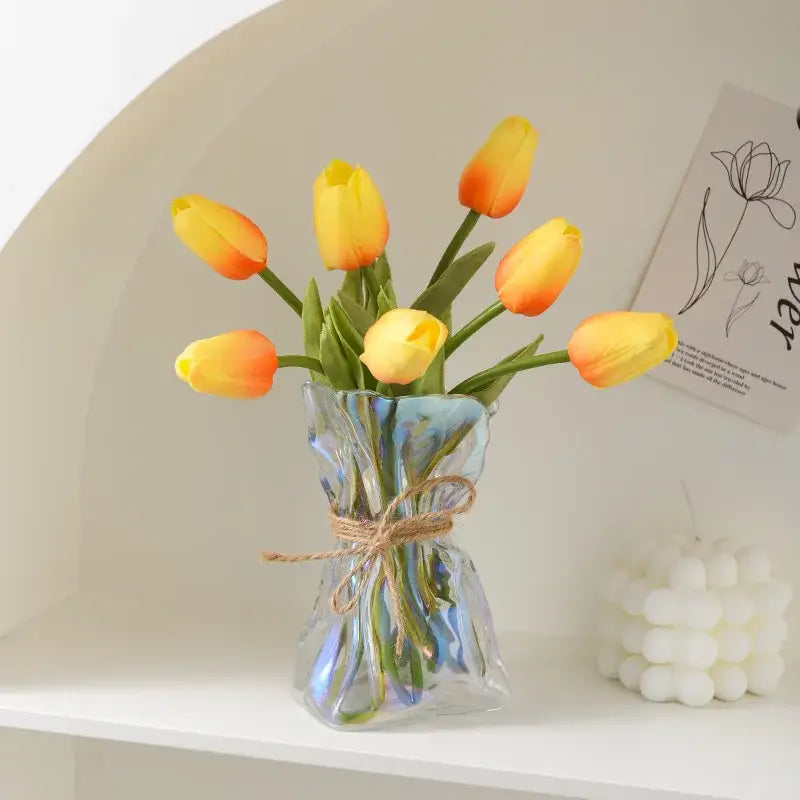 Handcrafted clear glass folded road vase with twine bow holding artificial yellow and orange tulips for living room decorbites clear glass decor