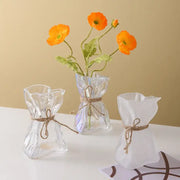 Three handcrafted clear glass folded road vases with crinkled shapes and rustic twine ties for living room decorbites decor