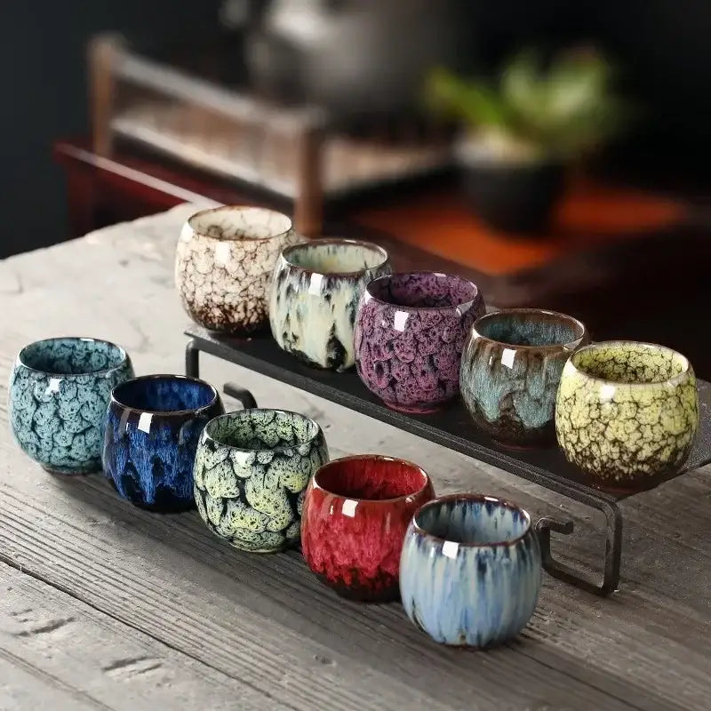 A collection of handcrafted colorful egg style ceramic tea cups with vibrant crackled glazes for dining room use