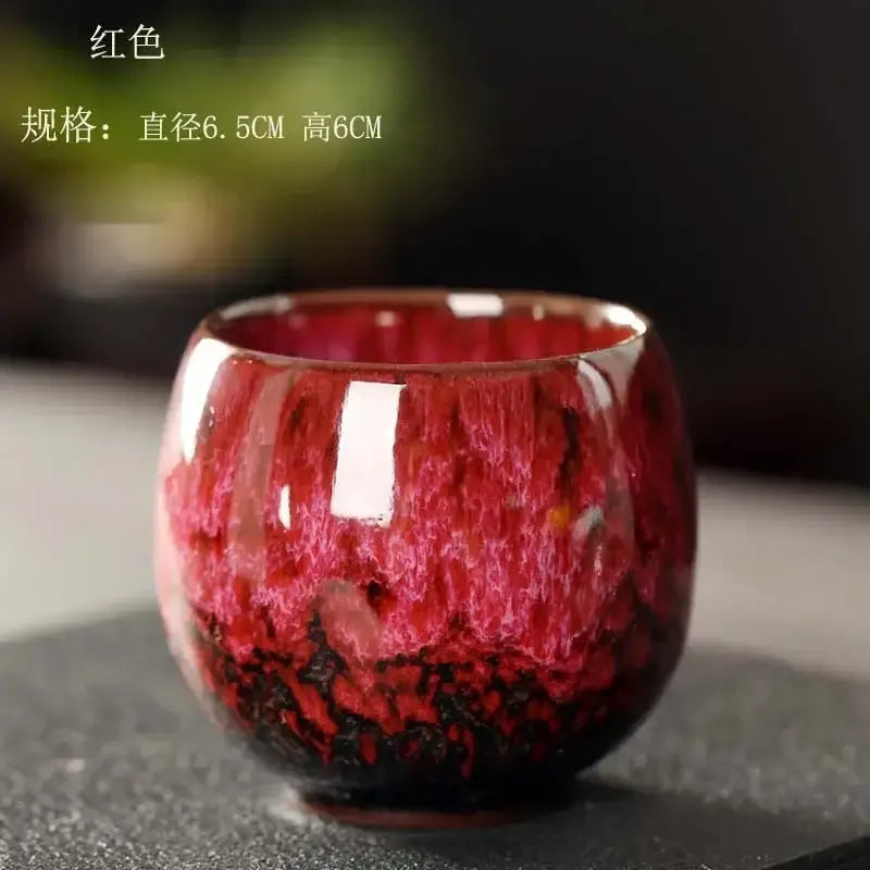 A glossy red egg style ceramic tea cup with swirling deep crimson and black glaze for stylish dining room use