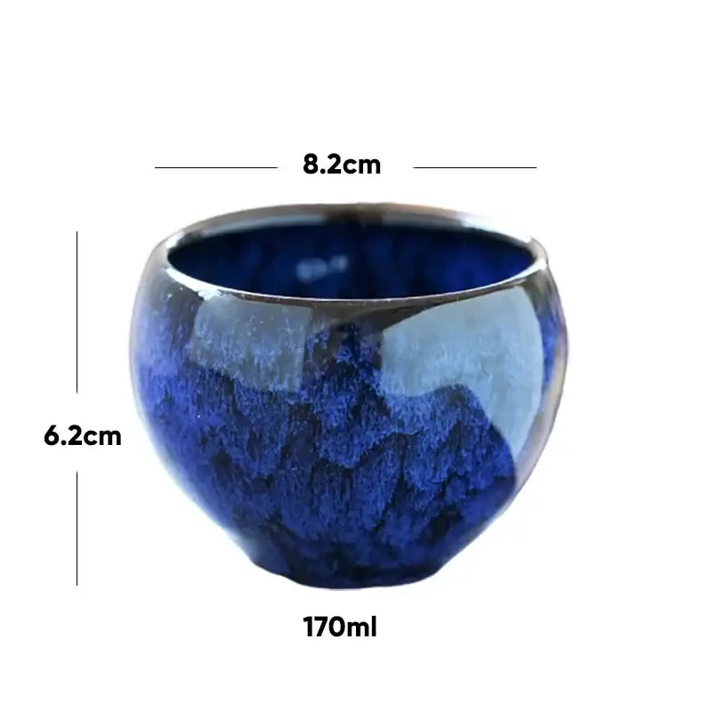 Handcrafted ceramic coffee cup with glossy deep blue crackle glaze and slightly flared rim for dining room use