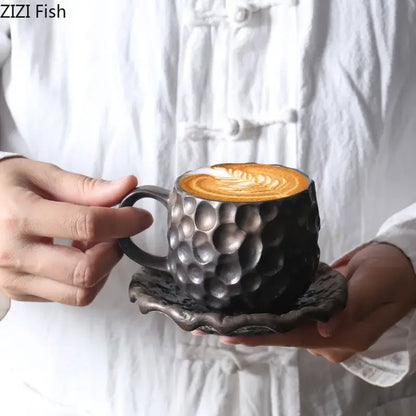 Black hammered ceramic mug with matching saucer featuring textured hammer pattern porcelain and latte art