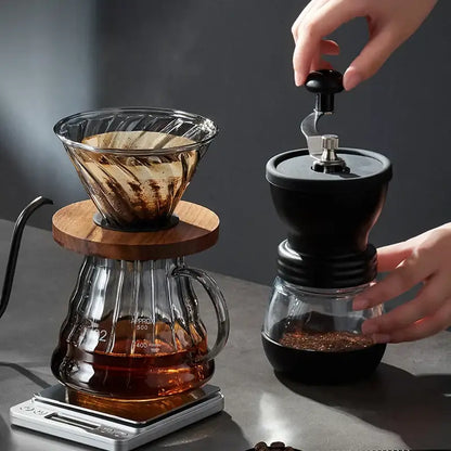 Black manual coffee grinder with glass base and metal knob included in handcrafted decorbites glass coffee brewer set