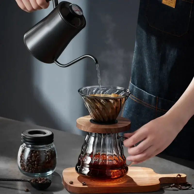 Black matte gooseneck kettle pouring hot water into handcrafted decorbites glass coffee brewer pour over set