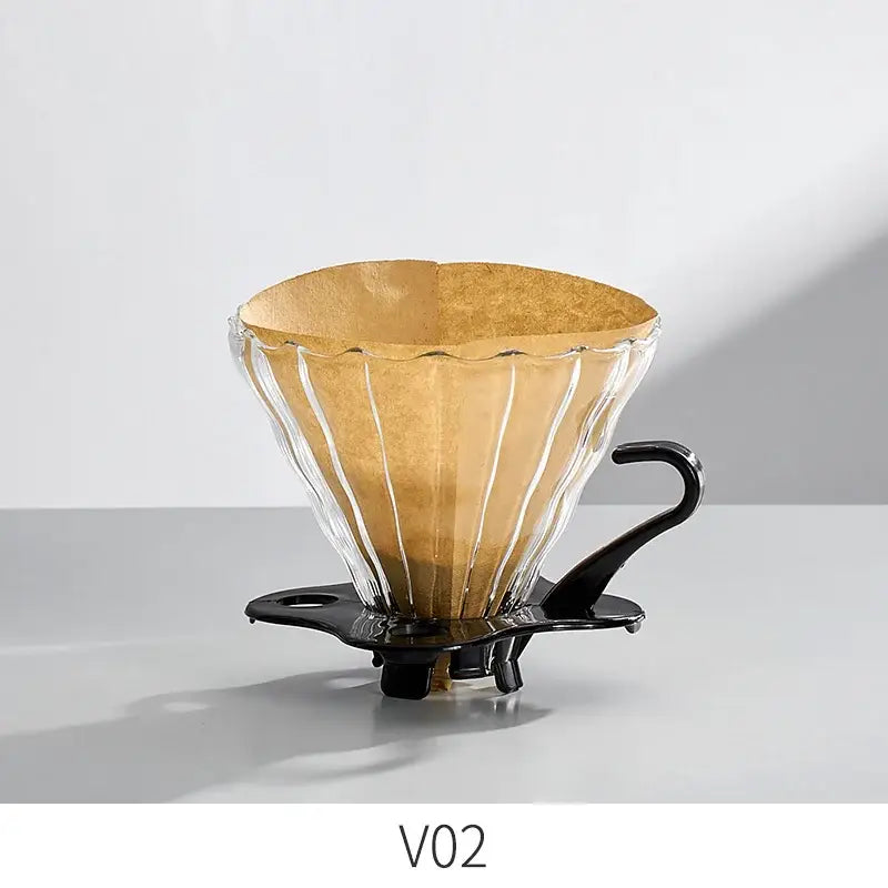 Handcrafted decorbites glass coffee brewer with fluted design, black metal handle, and golden-brown filter paper