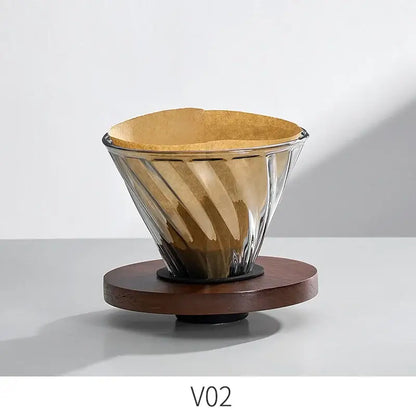 Handcrafted decorbites glass coffee brewer with ribbed twisted design and brown paper filter on dark wooden base