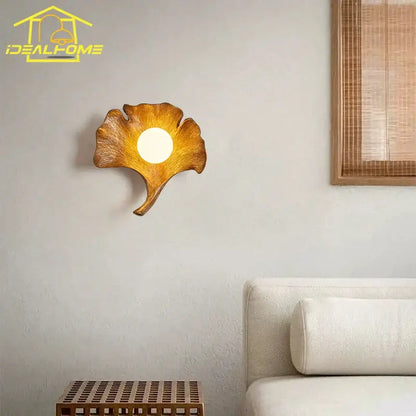 Warm-toned handcrafted wooden wall lamp shaped like a ginkgo biloba leaf with resin detail by decorbites for bedroom decor