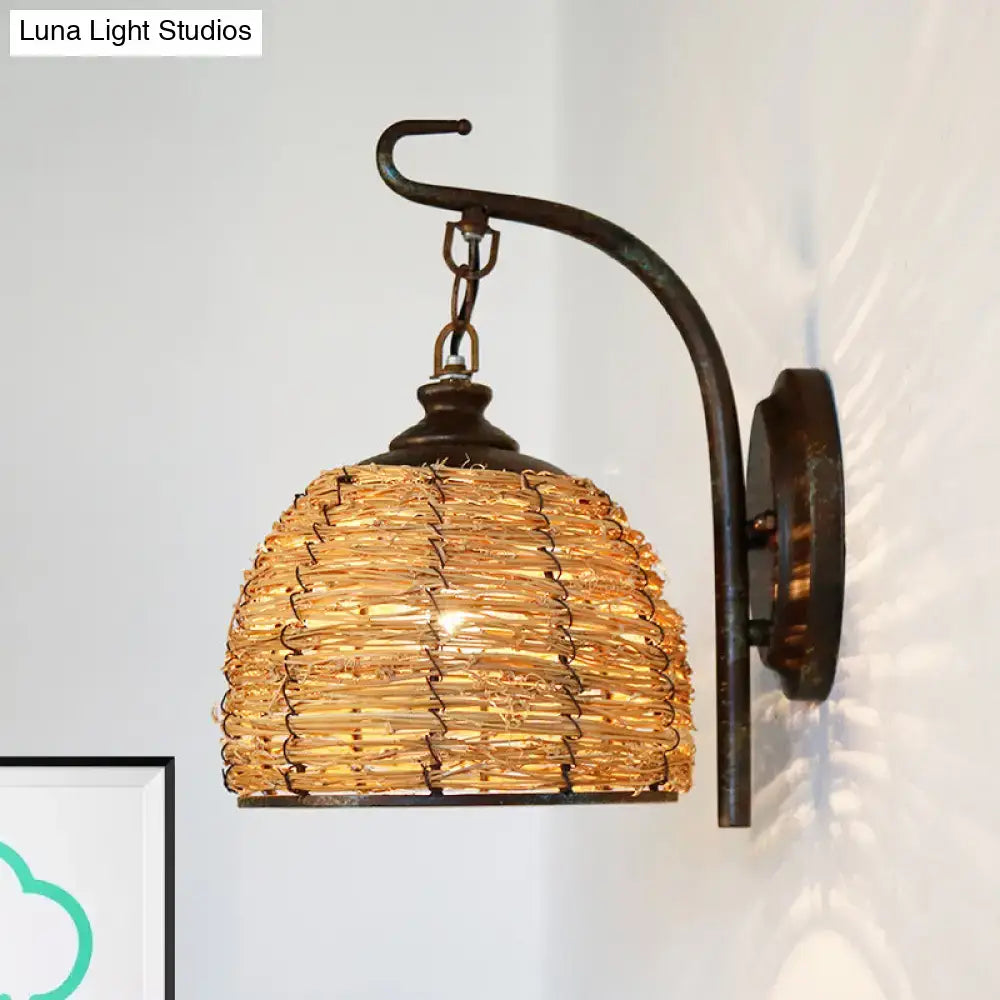 Handmade asian rattan dome wall sconce with a curved dark metal arm and golden-brown woven shade fixture type wall lamp