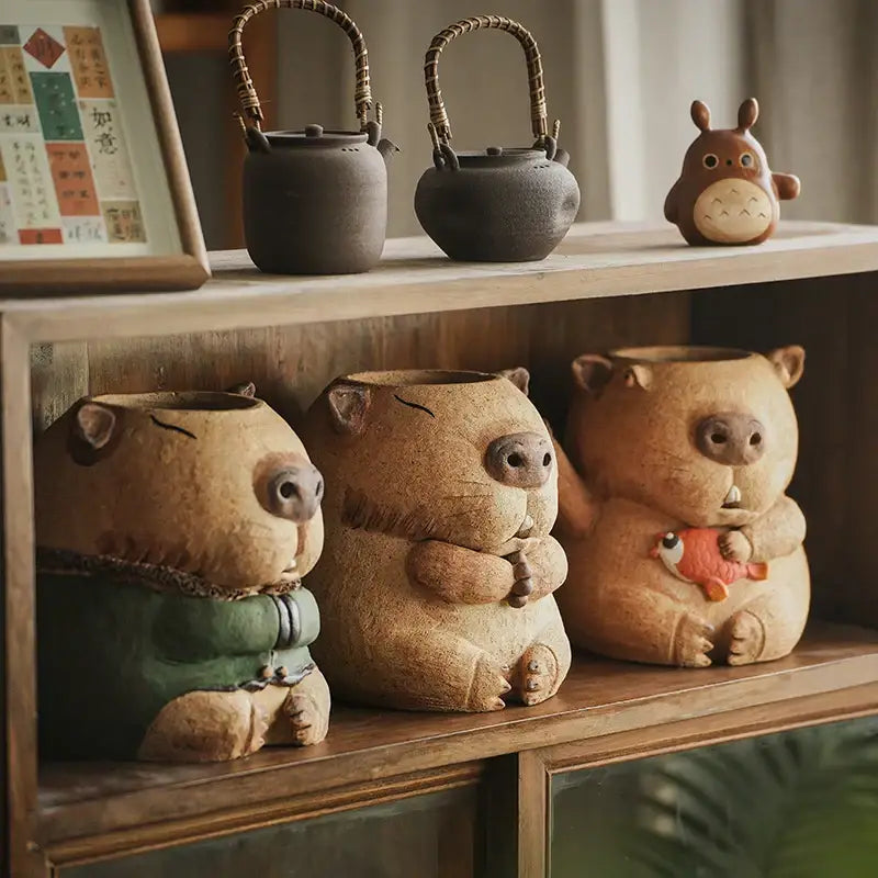 Tan ceramic pig-shaped planters with textured surfaces and whimsical details for carbon oven surrounding stove use