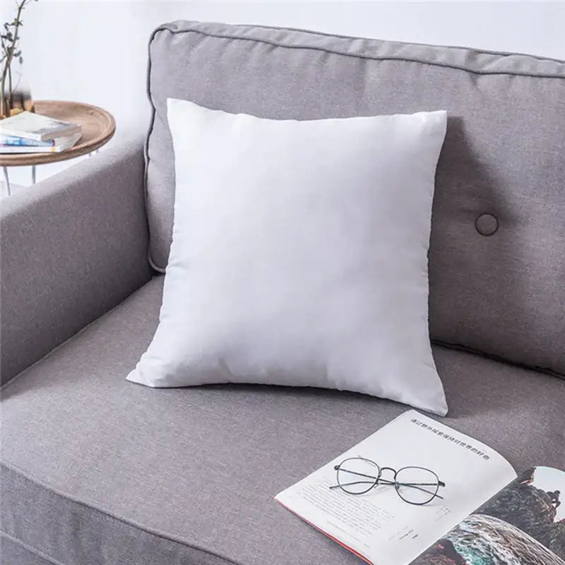 White square handmade flower cushion cover with soft fabric texture resting on gray sofa decorbites handmade flower
