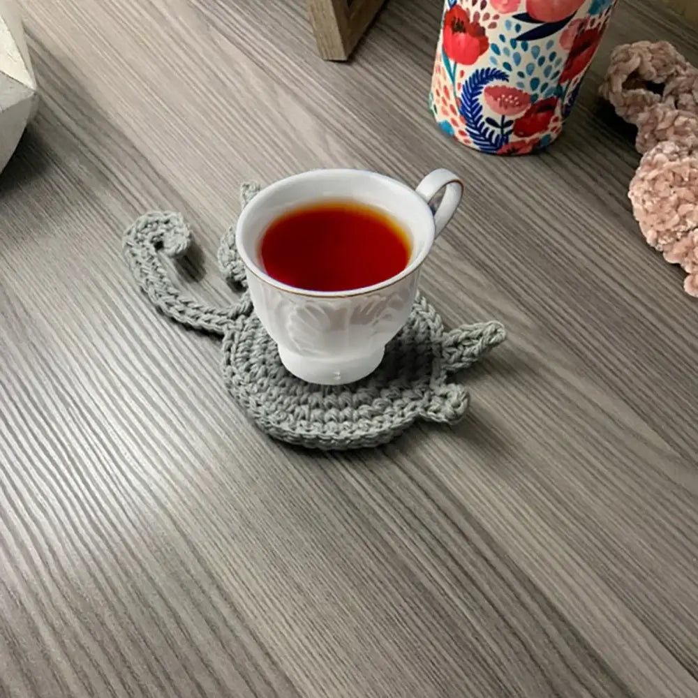 Handmade gray crocheted cat butt coaster showing back side in set of 4 for dining room decorbites cat butt coasters
