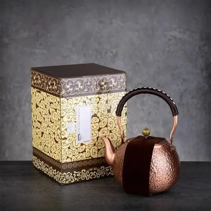 Handmade hammered copper tea pot with knitting handle and dark brown velvet cover beside ornate gift box decorbites handmade copper
