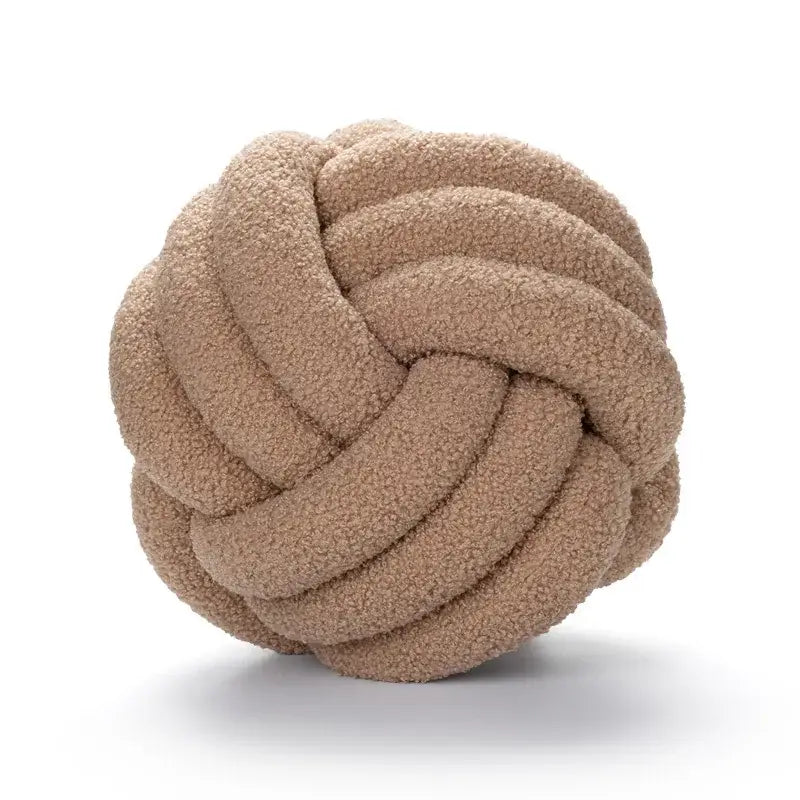 A plush beige handmade knotted boucle circle pillow with a soft textured surface for bedroom decor