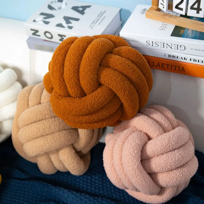 Soft plush knotted boucle circle pillows in warm orange beige and blush pink for bedroom decor