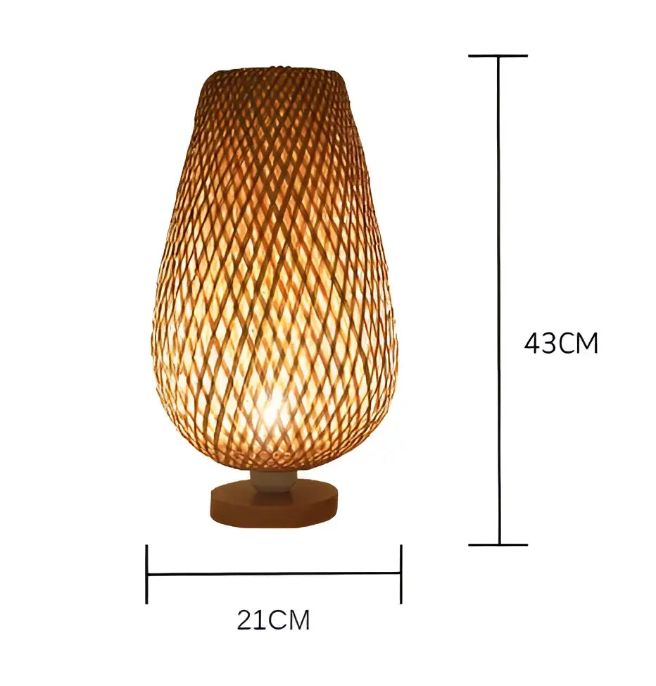 A warm-toned handmade bamboo table lamp with a tapered cylindrical shade and wooden base for bedroom use