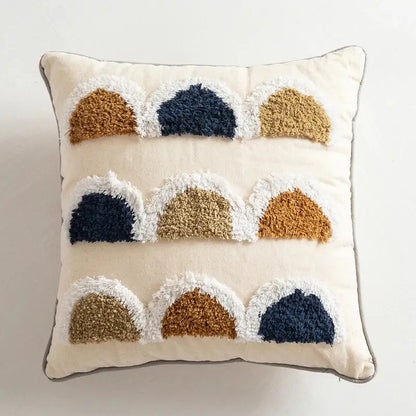Cream-colored pillow cover with navy and tan textured semi-circular appliqués and white fringe decorbites handmade moroccan geometric design