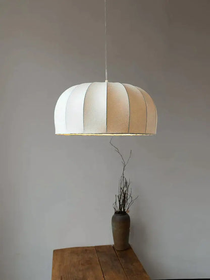 A modern silk pendant lamp with off-white and beige striped dome shade suspended by a thin cord for dining room