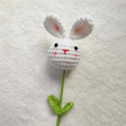 Handmade sunflower bouquet featuring a white crocheted bunny flower with pink ears attached to a green stem and leaves