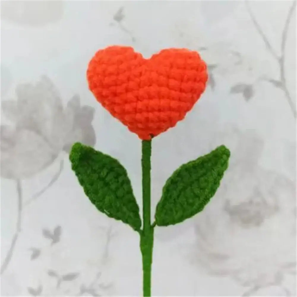 Hand-crocheted orange heart-shaped flower with green leaves in handmade sunflower bouquet crochet bunny bedroom decor