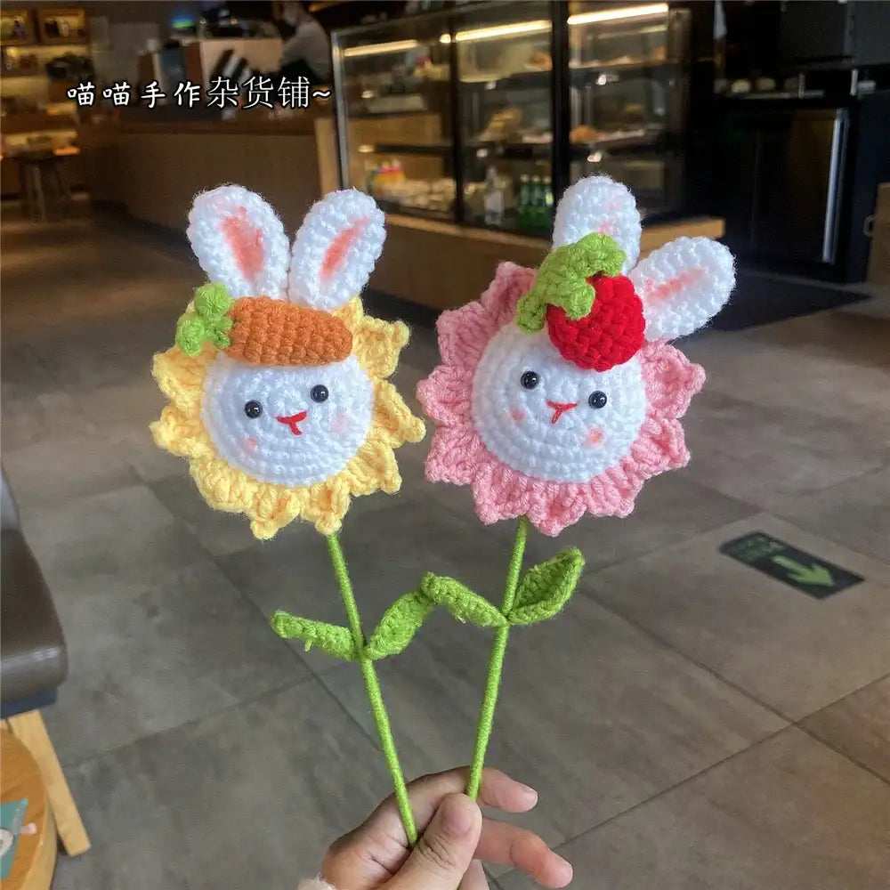 Two handmade sunflower bouquet crochet bunny ornaments with pink and white pig-faced blooms on soft yarn stems