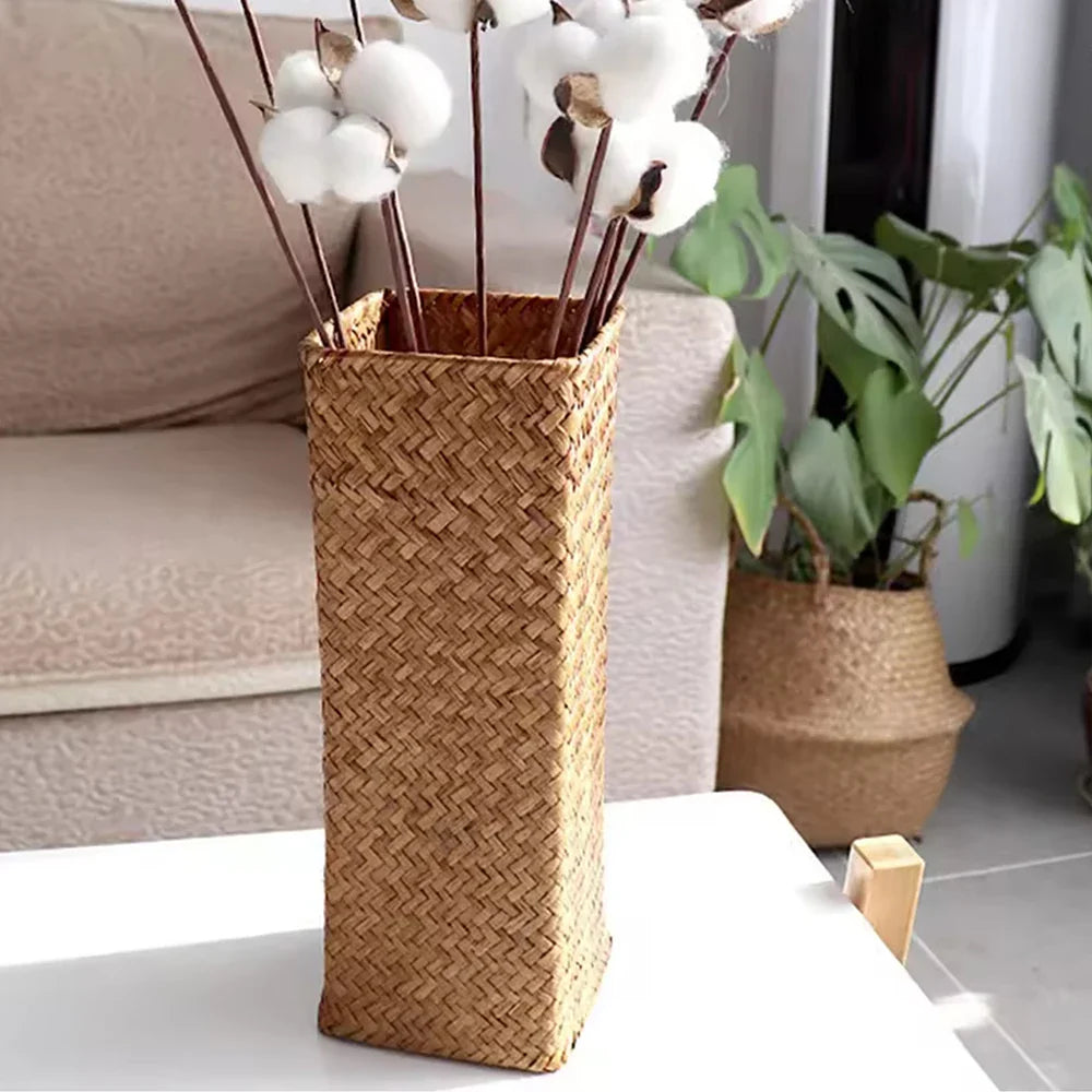 Handmade tall rectangular woven rattan vase with natural brown hue and herringbone pattern for flower arranging