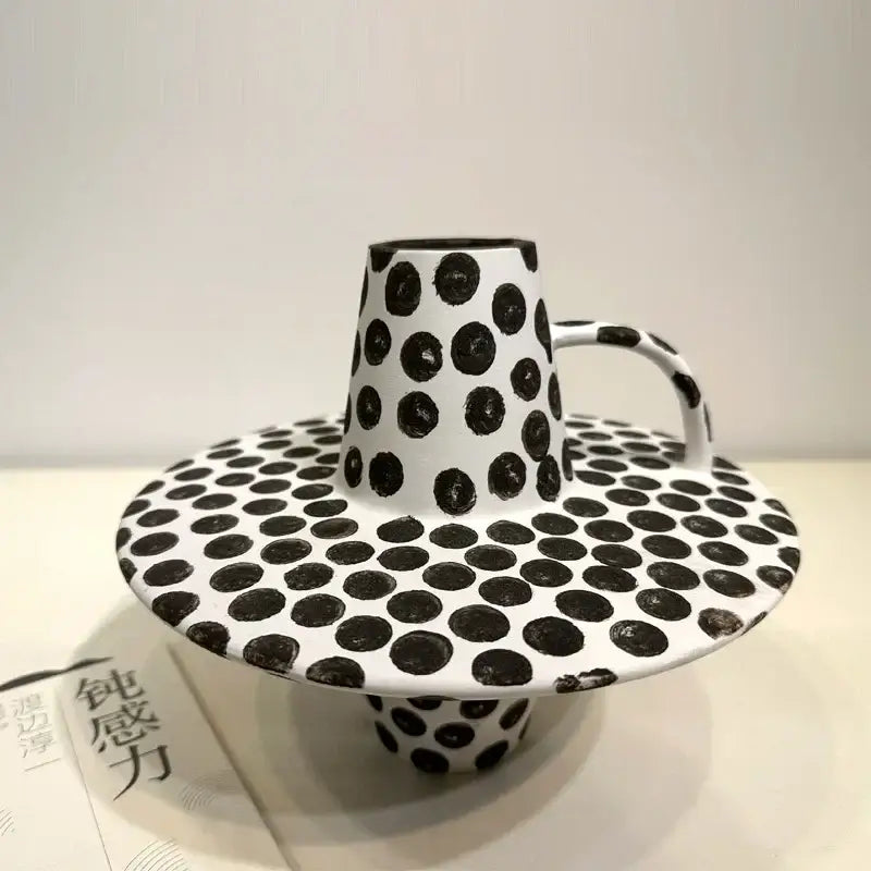 A handpainted black white dots ceramic mug and saucer set featuring white dots in a decorbites black white design