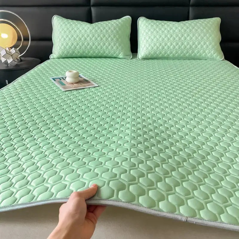 Light green hexagonal-patterned cooling mattress pad with quilted texture and gray border as part of bed sheet set