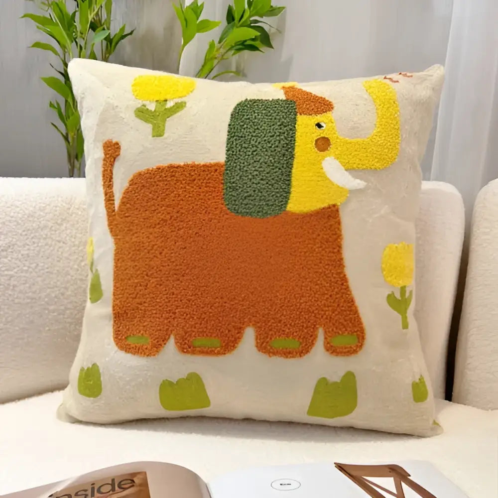A cozy cream-colored throw pillow featuring a playful orange and yellow elephant with green accents in cartoon oil painting embroidery style