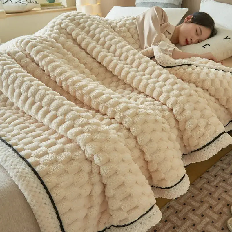 Cream-colored plush knit blanket with chunky weave and black trim featured as decorbites cozy coral fleece bed accessory