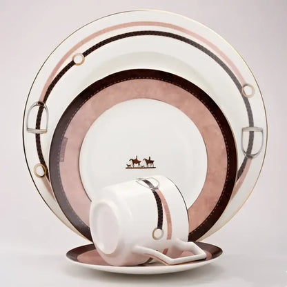 A white porcelain coffee cup and saucer with pink and brown stripes and horsebit accents from decorbites bone china tableware set