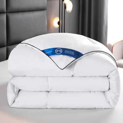 White quilted lightweight hotel style comforter with black piping and blue brand tag for queen and king beds