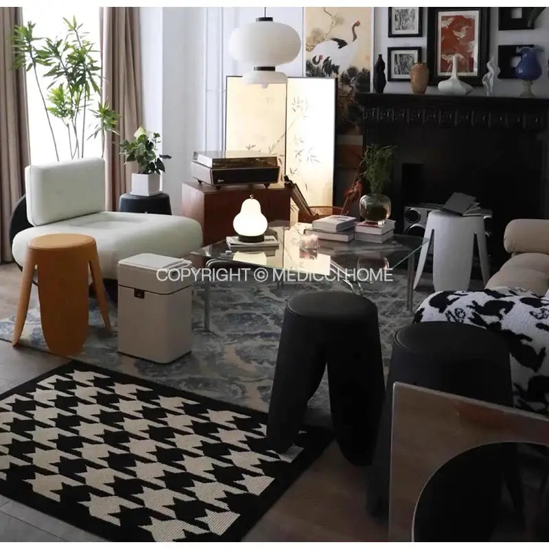 White upholstered armchair with wooden legs showcased on decorbites houndstooth black ivory area rug in living room