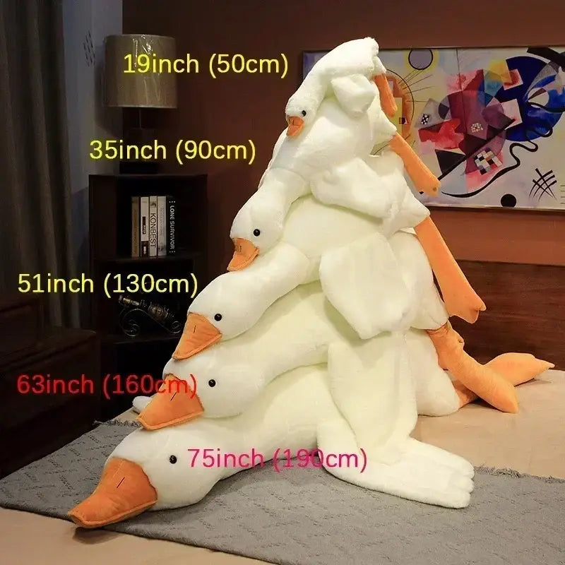 A plush white huge goose body pillow with orange beak and feet stacked in a pyramid for decorbites huge goose decor