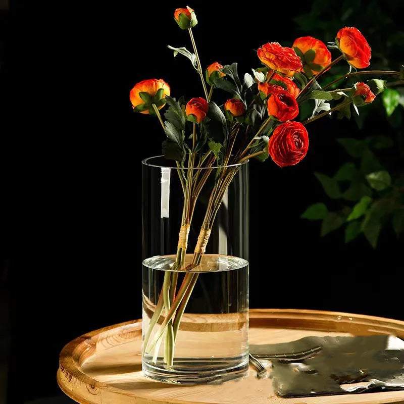 Clear cylindrical glass vase with vibrant orange and red ranunculus flowers for desktop hydroponic plant decoration