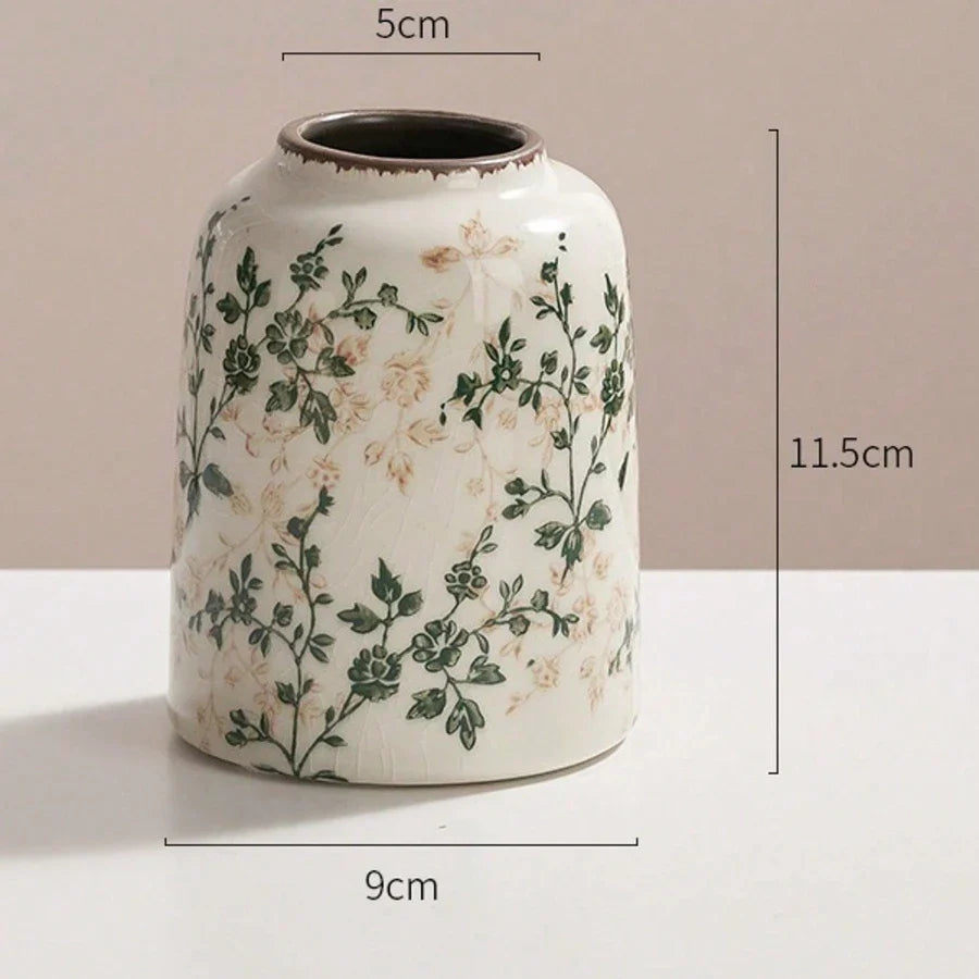A white ceramic ice crackle vase with hand-painted green and beige floral pattern for home and office decor