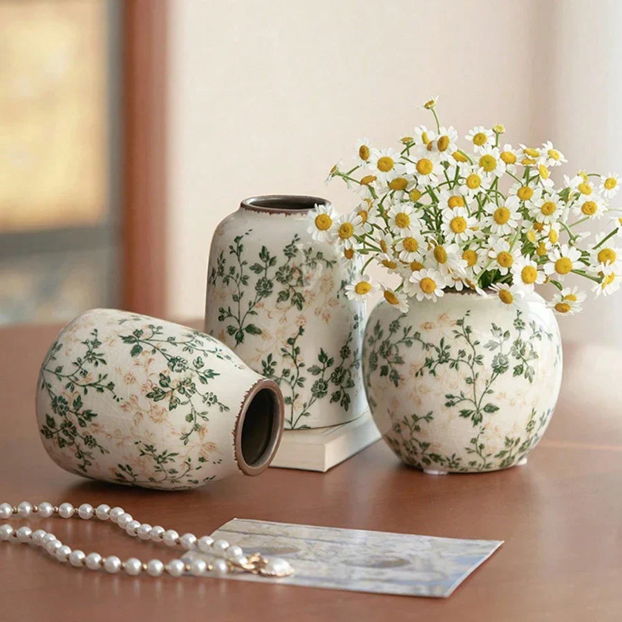 Three handmade ice crackle ceramic vases with green floral pattern on off white background for flower display