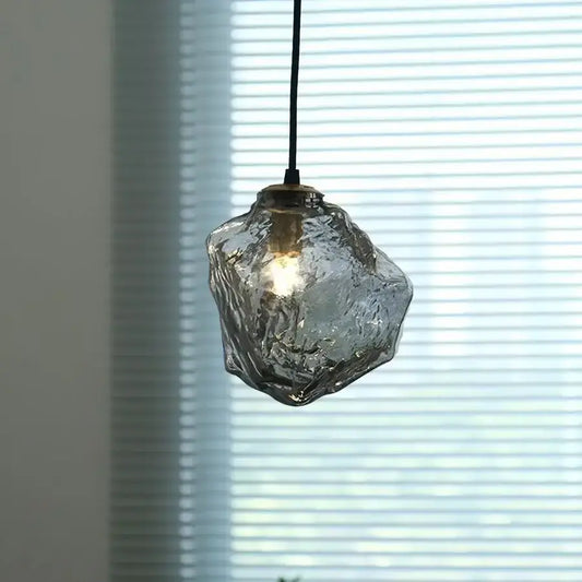 Ice cube textured glass pendant light with adjustable 3-color warm glow and black cord suspension as a dining room focal point