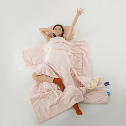 Soft pink quilted decorbites ice silk cooling blanket with plush texture and subtle stitching for bedroom comfort