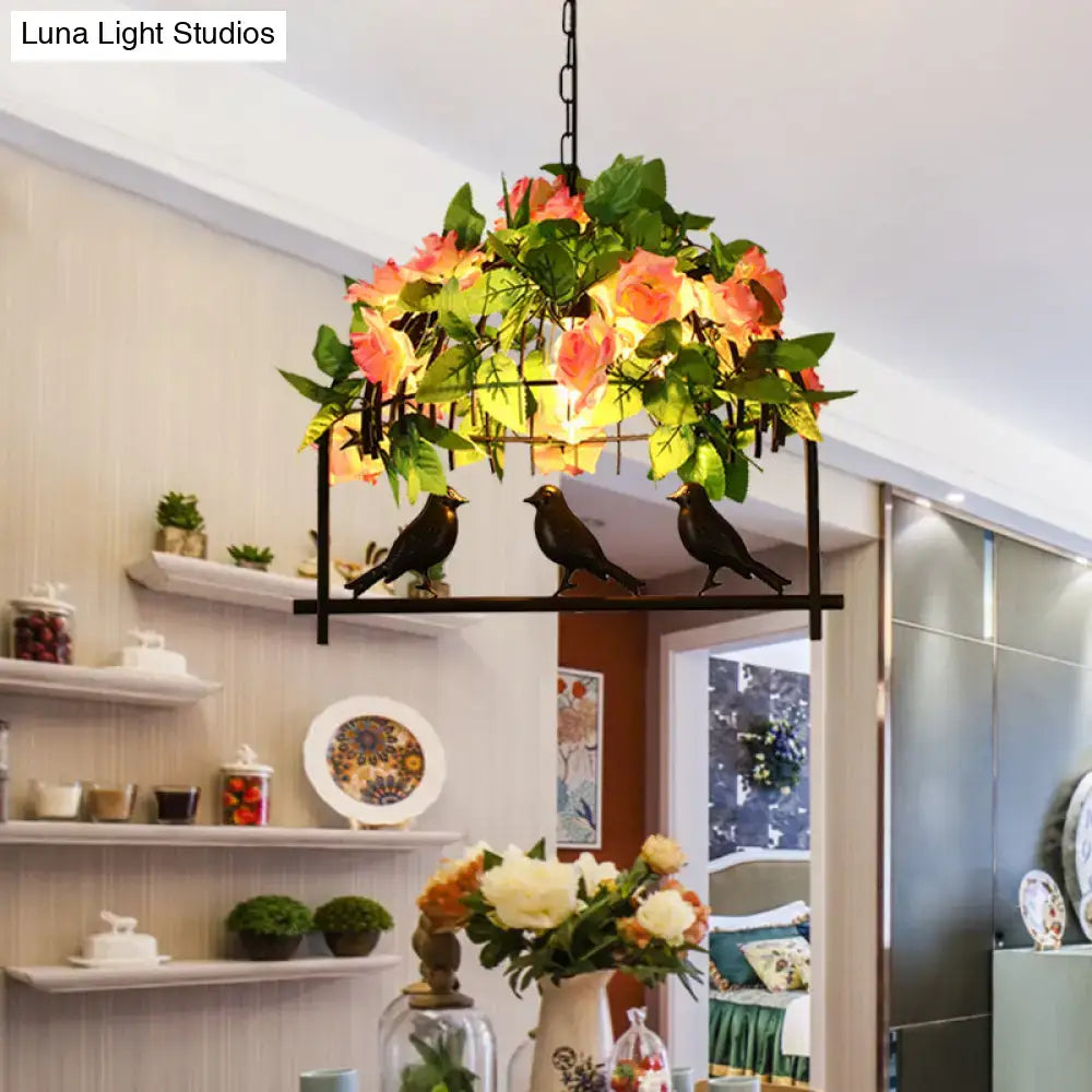 DecorBites™ iron industrial birdcage island pendant in black finish with down lighting, artificial roses, and black bird figurines
