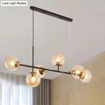Modern black metal 6-light island pendant with clear glass globes brass accents and amber milky white gradient shades