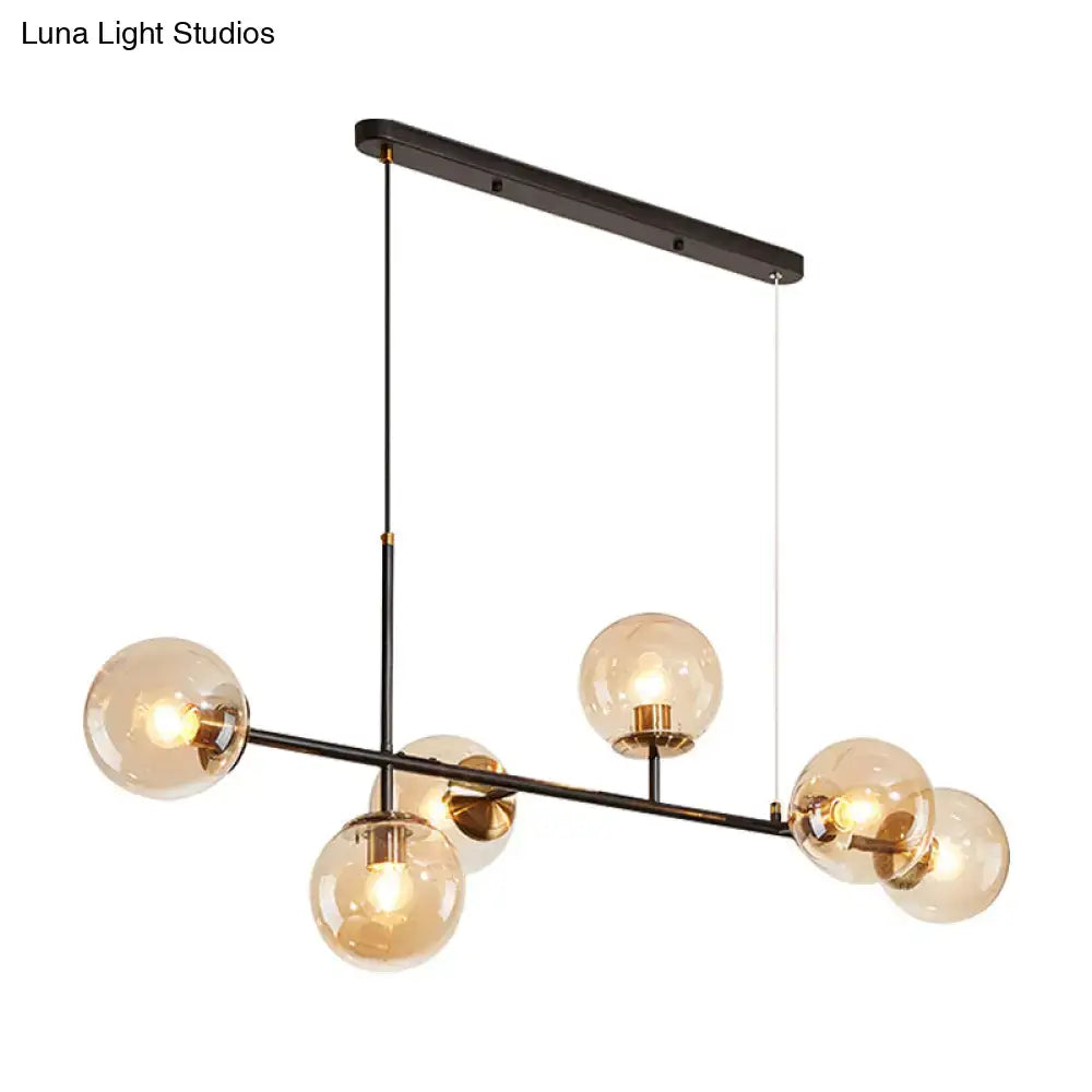 Modern black metal 6-light island pendant with six warm amber glass globes and adjustable cord by DecorBites