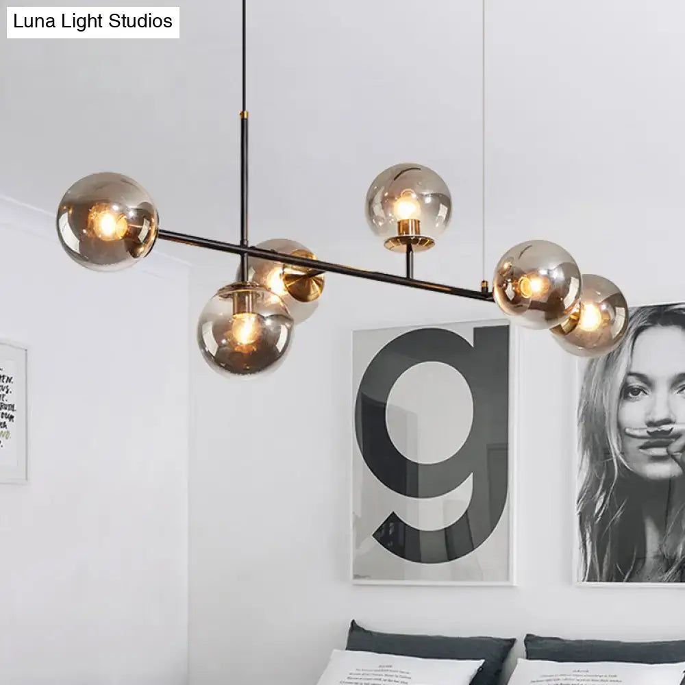 Modern black metal 6-light island pendant with amber spherical glass globes and adjustable cord by DecorBites