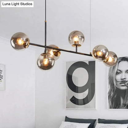 Modern black metal 6-light island pendant with amber spherical glass globes and adjustable cord by DecorBites