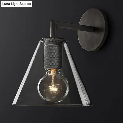 Industrial black and brass wall lamp with matte black metal arm and clear glass fixture featuring exposed edison bulb