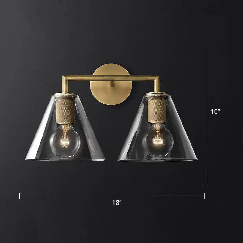 Brass-finished wall lamp with two clear glass conical shades and exposed bulb sockets industrial fixture type