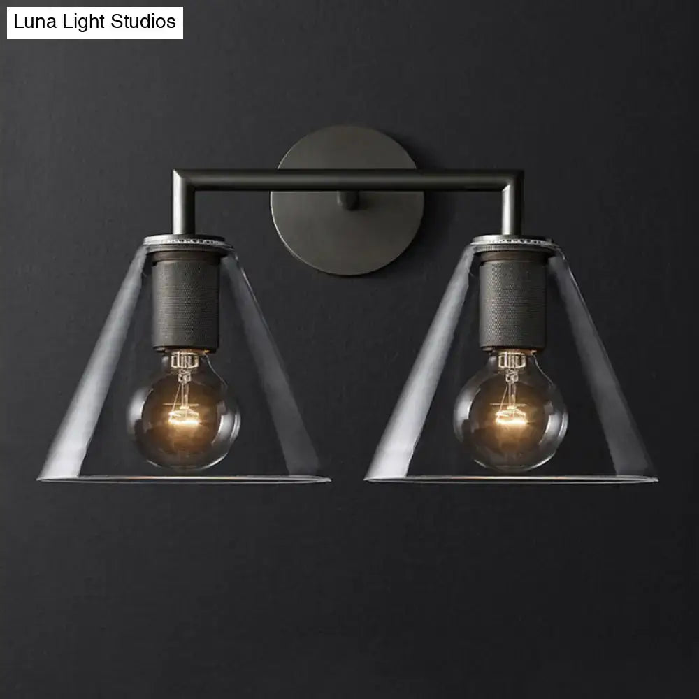 Industrial black and brass wall lamp featuring a clear glass fixture with two exposed filament bulbs for bedroom use