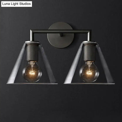 Industrial black and brass wall lamp featuring a clear glass fixture with two exposed filament bulbs for bedroom use