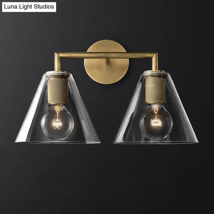 Brass-finished industrial wall lamp with clear glass conical shades and exposed filament bulbs for bedroom fixture type